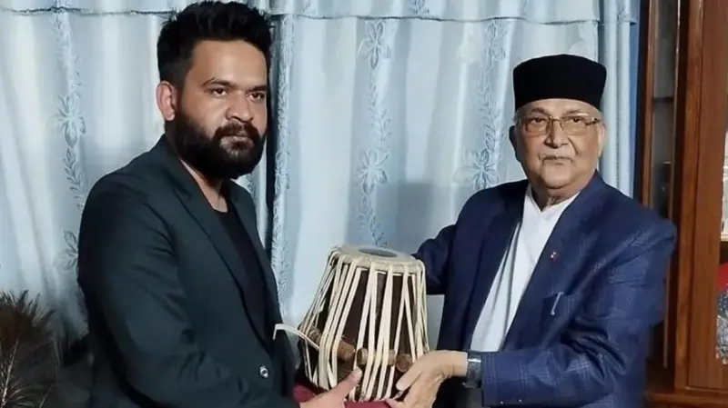 यो फाइल तस्बिरमा ओलीले बालेनलाई मादल उपहार दिँदे गरेको देखिन्छ