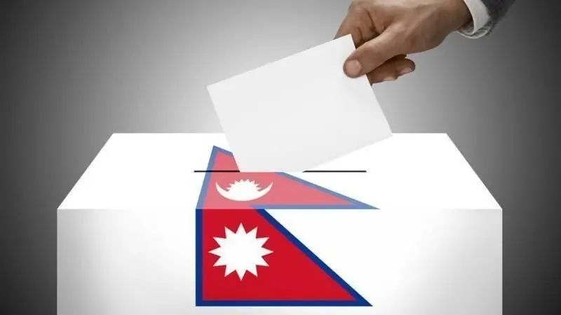 नेपाल मतदानको साङ्केतिक तस्बिर। झण्डासहितको सेतो बाकसमा एउटा कागज देख्न सकिन्छ।